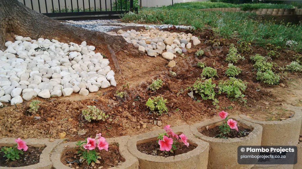 Landscaped garden bed with stones by Plambo Projects
